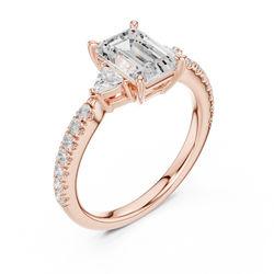 Side profile view of the Emerald Cut engagement ring highlighting the 3 stone basket setting and pave diamond band design