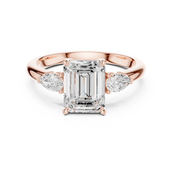 Front top down view of a 14K Gold Emerald Cut Lab Diamond 3 Stone Engagement Ring featuring a 2.00 Carat 8.50x6.50mm central emerald cut stone flanked by two brilliant pear cut side stones set in four prong baskets.