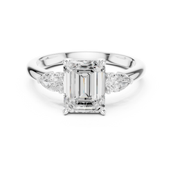 Hand model wearing a 14K gold emerald cut three stone engagement ring in size US 7 showcasing natural finger proportions and high luster brilliant diamond reflection.