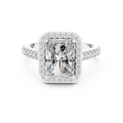 Top down aerial view highlighting the perfectly symmetry of 9x7mm radiant cut center stone framed by a delicate halo of round lab grown diamonds in solid 10k gold.

