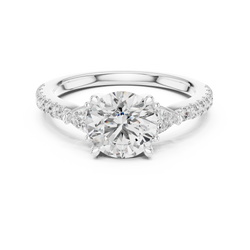 Top down birds eye perspective of the three stone round cut diamond ring showing precise geometric alignment of the center gemstone, triangular trillion side gems, and uniform pave diamond channel set along the upper shank, engineered by master jewelers at HB Prestige Jewels.