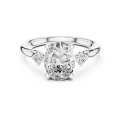 Top down studio image displaying the exact symmetry of a 2.15 ct total weight lab grown diamond three stone ring in 18k white gold background.

